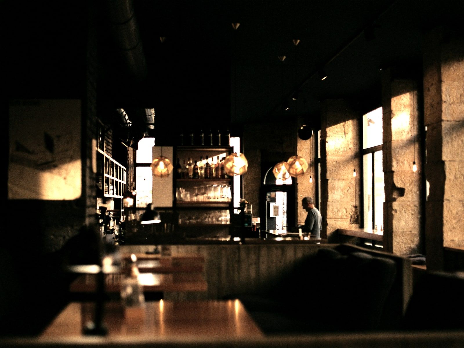 The long room after opening, tables down one side and the window light behind them.